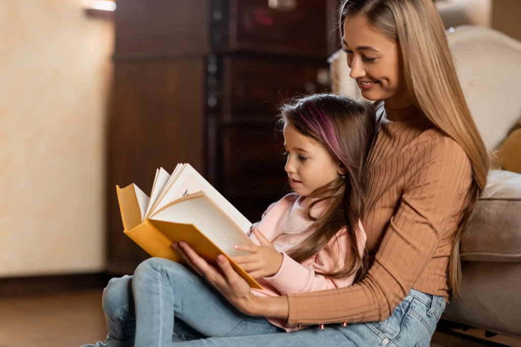 portrait-of-happy-mother-and-daughter-reading-book